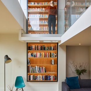 Modelo de sala de estar con biblioteca abierta, contemporánea, con paredes blancas y suelo de madera clara