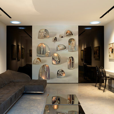 Example of a mid-sized trendy enclosed concrete floor and gray floor family room design in London with white walls and a wall-mounted tv