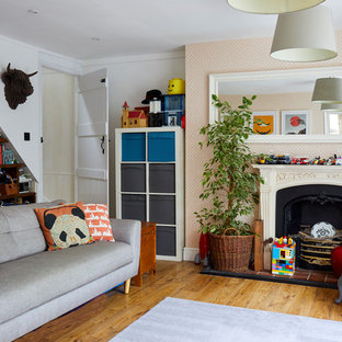 Inspiration for a farmhouse enclosed games room in Surrey with white walls, medium hardwood flooring, a standard fireplace and brown floors.