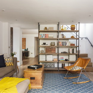 Bohemian games room in London with a reading nook, white walls, medium hardwood flooring and no fireplace.