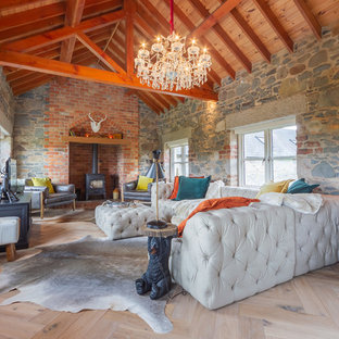 Inspiration for a farmhouse games room in Belfast with multi-coloured walls, light hardwood flooring, a wood burning stove and a freestanding tv.