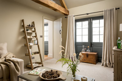 Diseño de sala de estar cerrada campestre pequeña sin chimenea y televisor con paredes beige, moqueta y suelo beige
