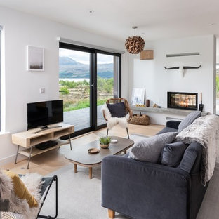 Design ideas for a medium sized scandi games room in Cornwall with white walls, light hardwood flooring, a two-sided fireplace, a freestanding tv and beige floors.