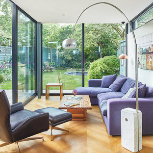 Large contemporary enclosed games room in London with grey walls, laminate floors, a wall mounted tv, beige floors and no fireplace.