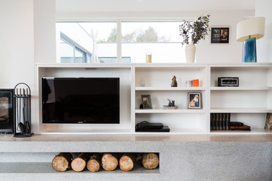 На фото: гостиная комната в современном стиле с белыми стенами и телевизором на стене с