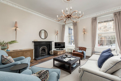 Großes, Abgetrenntes Klassisches Wohnzimmer mit beiger Wandfarbe, dunklem Holzboden, freistehendem TV, braunem Boden und Kamin in Edinburgh