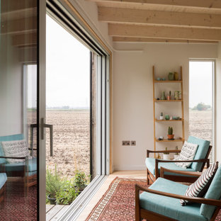 Design ideas for a contemporary enclosed games room in Cambridgeshire with white walls, light hardwood flooring, no fireplace, no tv, beige floors and exposed beams.