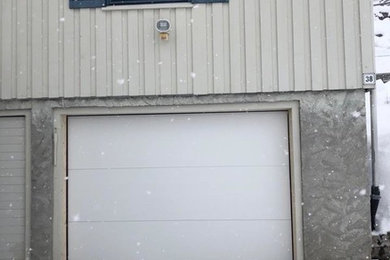 На фото: пристроенный гараж среднего размера в скандинавском стиле с мастерской для одной машины с