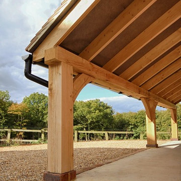 4 Bay garage with a sweeping roof line tied into log-store