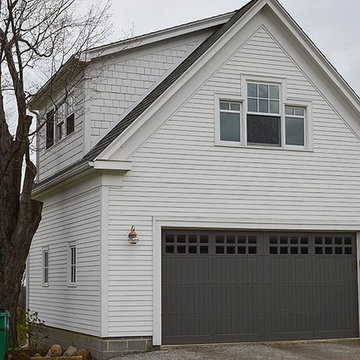 Attached garage with white wood siding