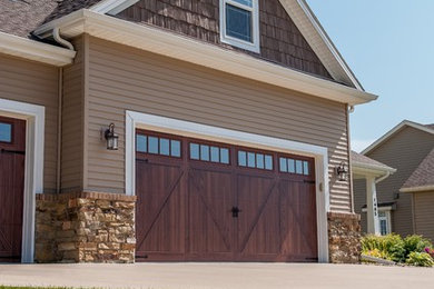 Garage - large transitional attached three-car garage idea in Cleveland