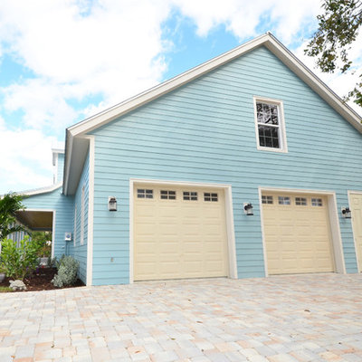Example of a mid-sized island style attached two-car garage design in Miami