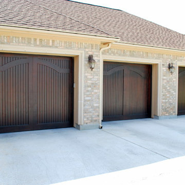 Elegant Arch Wood Doors in a Carriage Style by Cowart Door Systems