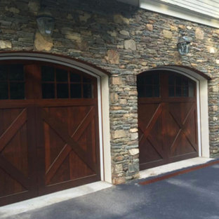 Example of a large mountain style attached three-car garage design in New York