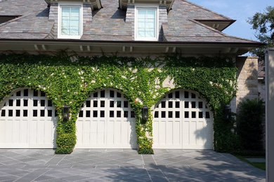 Example of a large tuscan attached three-car garage design in Austin