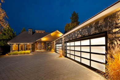 Garage - large contemporary attached three-car garage idea in Calgary