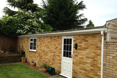 This is an example of a small modern detached double garage in Other.