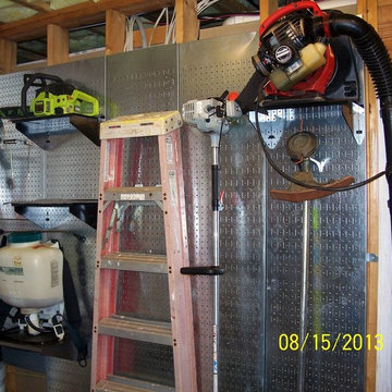 Industrial metal pegboard wall with pegboard panels attached to studs on 16in ce