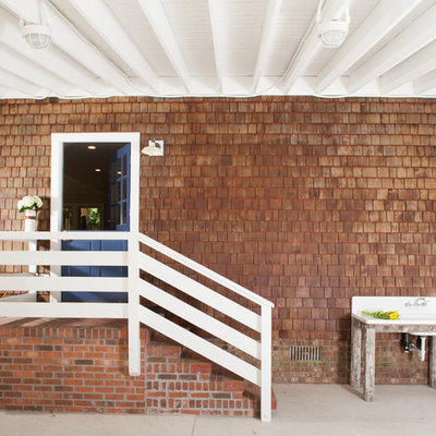 Example of a mid-sized beach style attached two-car carport design in Other