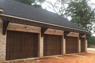 Example of a large mountain style attached four-car garage design in New Orleans