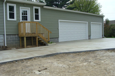 Example of a large classic attached three-car garage design in Other