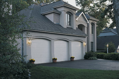 Inspiration for a large transitional attached three-car garage remodel in Kansas City