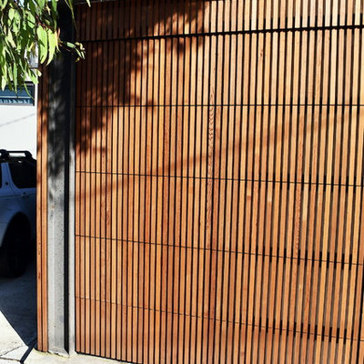 Example of a mid-sized minimalist attached one-car carport design in Sydney