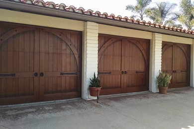 Garage - large mediterranean attached three-car garage idea in Orange County