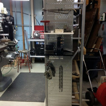 Wall Control metal pegboard mounted to the side of some industrial shelving crea