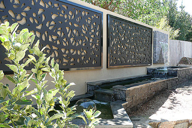 Foto di un giardino esposto a mezz'ombra di medie dimensioni e in cortile con fontane e pavimentazioni in pietra naturale