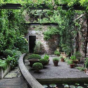Ejemplo de jardín industrial, en patio, con gravilla y jardín de macetas