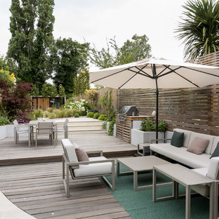 Inspiration for a large contemporary back garden in London with a potted garden and decking.