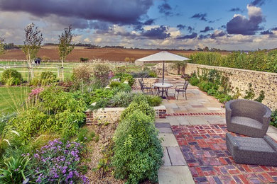 Mittelgroßer Landhaus Garten im Sommer, hinter dem Haus mit direkter Sonneneinstrahlung und Natursteinplatten in Sussex