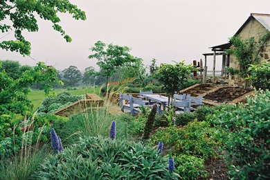 Foto de jardín de secano de estilo de casa de campo en patio trasero con exposición total al sol y adoquines de hormigón