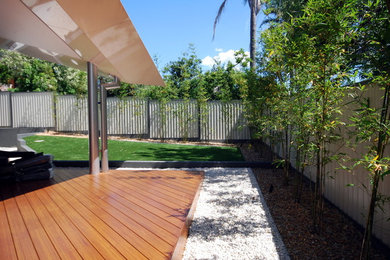 Modelo de jardín minimalista de tamaño medio en patio trasero con jardín francés y entablado