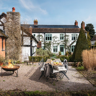 This is an example of a large farmhouse back garden in Other with a fire feature and gravel.