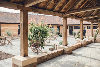 Imagen de jardín tradicional grande en patio con jardín francés y adoquines de hormigón