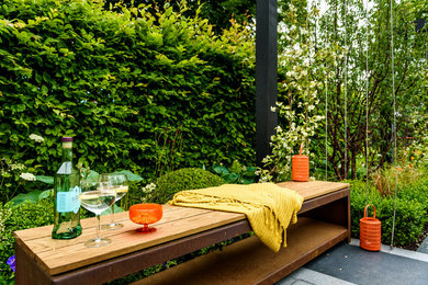 Imagen de jardín contemporáneo en verano en patio con exposición parcial al sol y adoquines de piedra natural