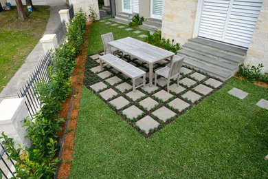 Modelo de jardín minimalista con exposición total al sol y adoquines de hormigón