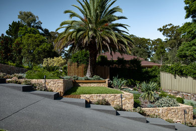 Diseño de jardín en patio delantero con muro de contención