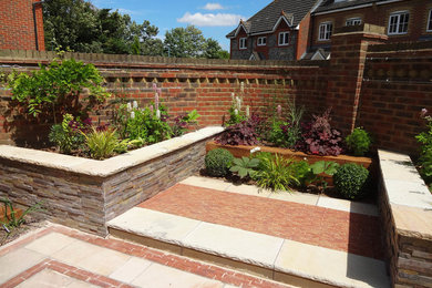 Immagine di un giardino formale design esposto a mezz'ombra di medie dimensioni e dietro casa in estate con pavimentazioni in pietra naturale