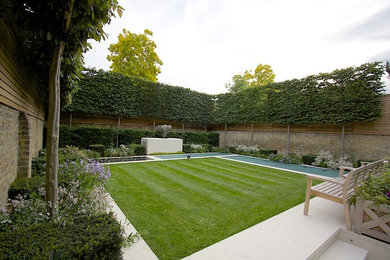 Foto de jardín actual de tamaño medio en patio trasero con jardín francés, jardín de macetas y adoquines de piedra natural