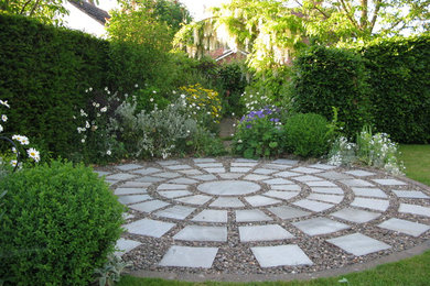 Design ideas for a contemporary back partial sun garden in West Midlands with natural stone paving.