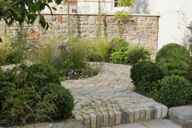 Foto de jardín tradicional pequeño en patio delantero con jardín francés, exposición total al sol y adoquines de piedra natural