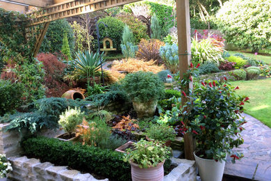 Foto di un grande giardino formale classico in ombra dietro casa in autunno con un giardino in vaso, gazebo e pavimentazioni in pietra naturale