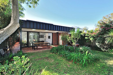Immagine di un giardino minimalista esposto a mezz'ombra di medie dimensioni e dietro casa in autunno con pavimentazioni in mattoni