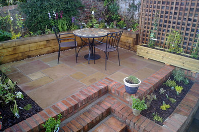 Small classic back full sun garden for summer in Other with brick paving.