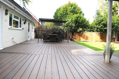 This is an example of a large contemporary back formal full sun garden in Surrey with decking.