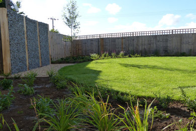 Diseño de jardín contemporáneo en patio trasero con jardín francés, exposición parcial al sol y gravilla