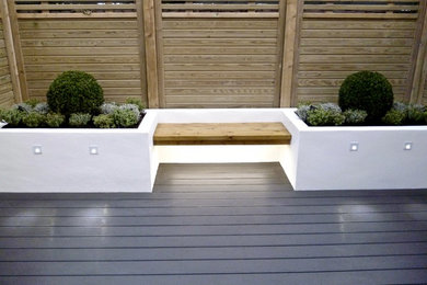 Cette image montre un jardin design avec une terrasse en bois.